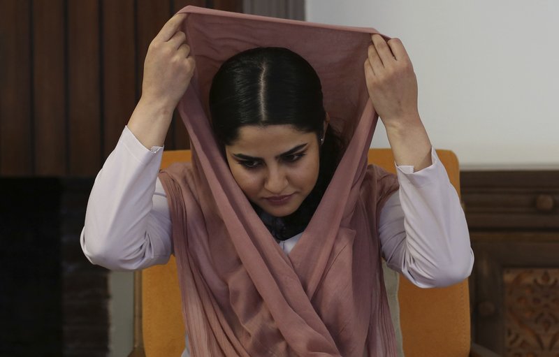 woman puting a hijab on