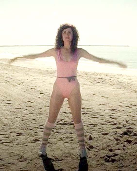 Apple TV’s show Physical starring Rose Byrne as Sheila Rubin wearing a blush pink 80s costume on the beach