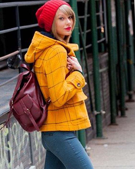 Taylor Swift in yellow jacket and a red cap