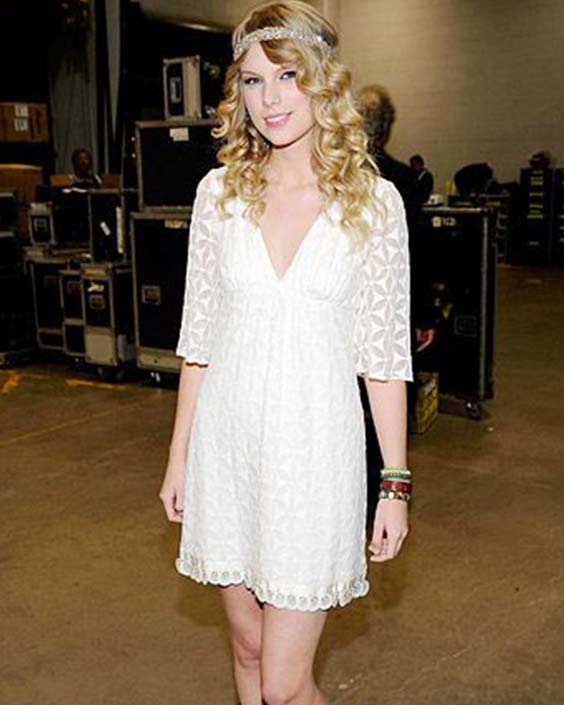 Taylor Swift in a white dress and cowboy shoes fearless era