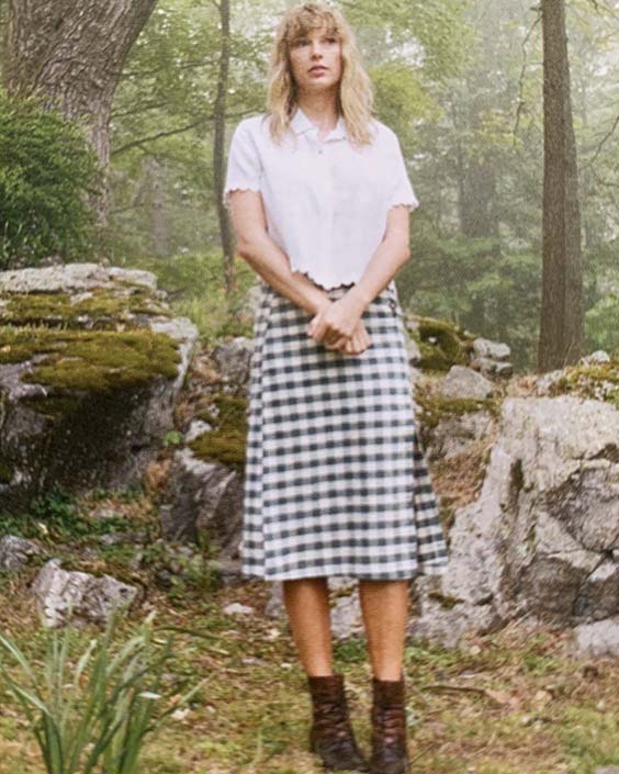 Taylor Swift in a plaid skirt and a white blouse for Folkore shoot